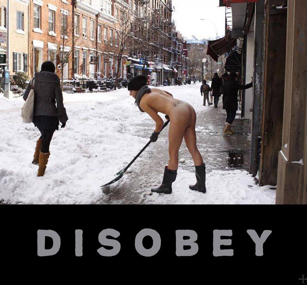 Naked woman shoveling snow in a city while bypasser does not care